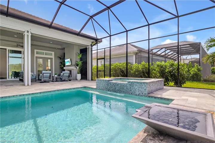 View of pool with an in ground hot tub, ceiling fan, a lanai, and french doors