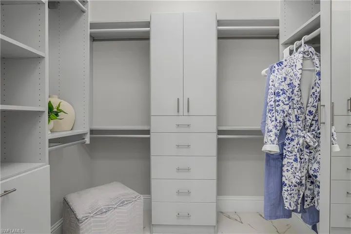 Professional closet built-in cabinets in both his/hers closets.
