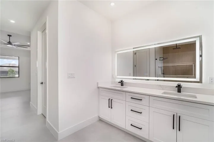 Bathroom featuring dual vanity and ceiling fan