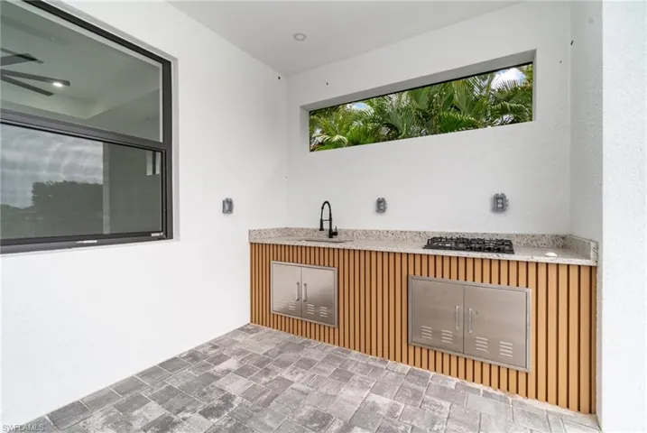 Bar featuring sink, tile patterned flooring, and black gas cooktop