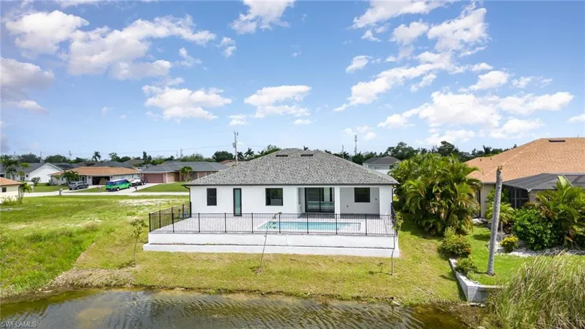 Back of house with a patio, a water view, and a yard-screen cage to be installed