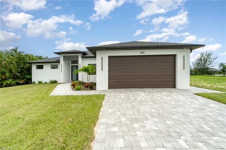 View of front facade featuring a garage and a front yard