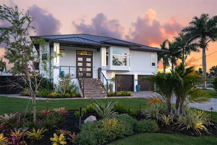 View of front of property with french doors, a yard, and a garage