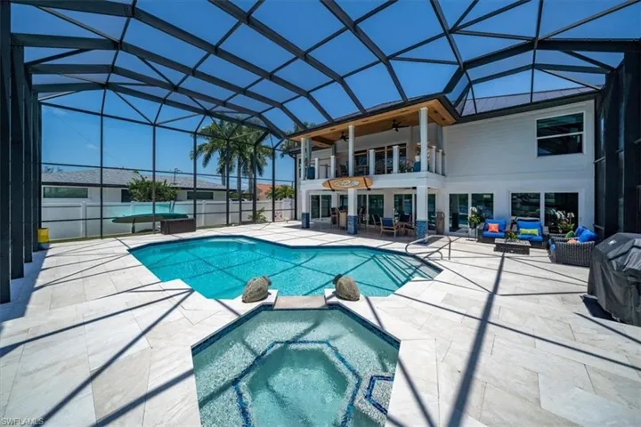 View of swimming pool with an in ground hot tub, an outdoor hangout area, a patio, glass enclosure, and ceiling fan