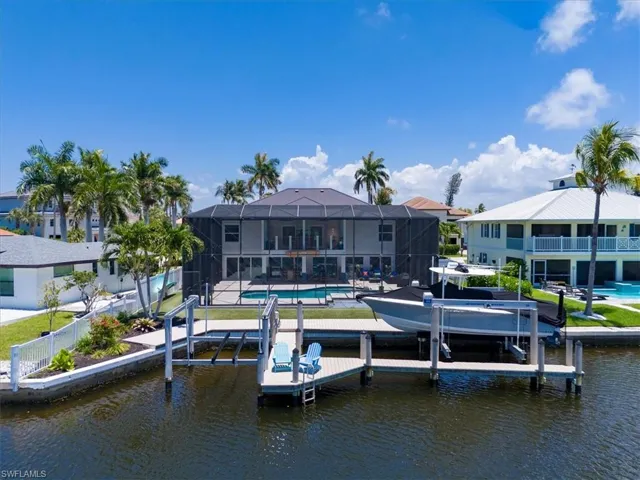 Dock area featuring a patio area, a water view, and glass enclosure