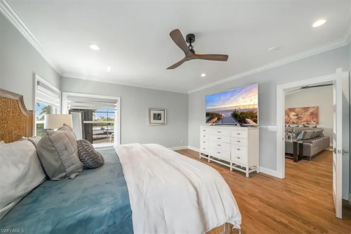 Bedroom with ornamental molding, hardwood / wood-style flooring, and ceiling fan