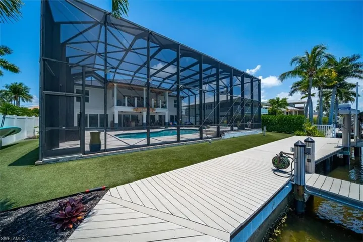 Dock area featuring a patio area, a yard, a water view, and a lanai