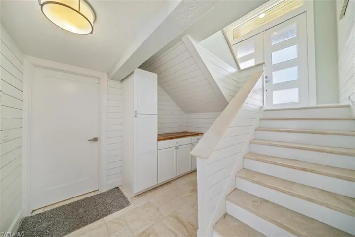 Stairs with wood walls and vaulted ceiling