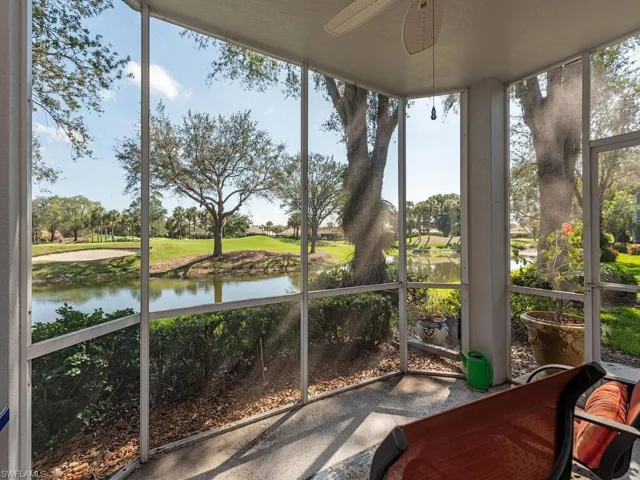 Sunroom / solarium featuring ceiling fan and a water view