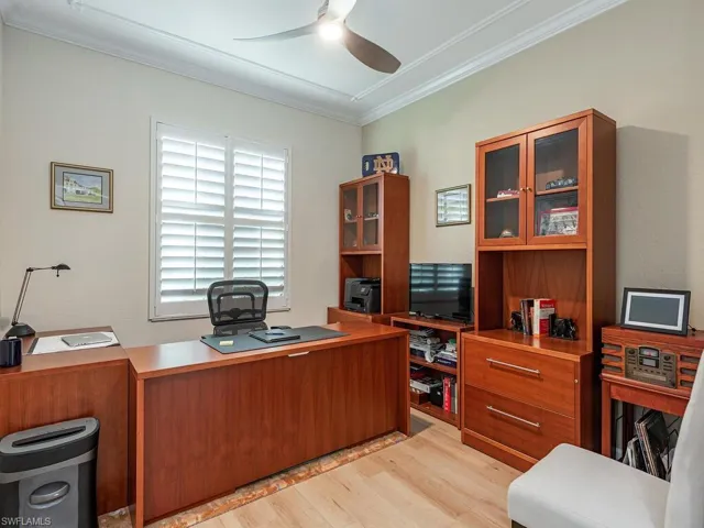 Home office featuring a ceiling fan, crown molding, and light wood finished floors