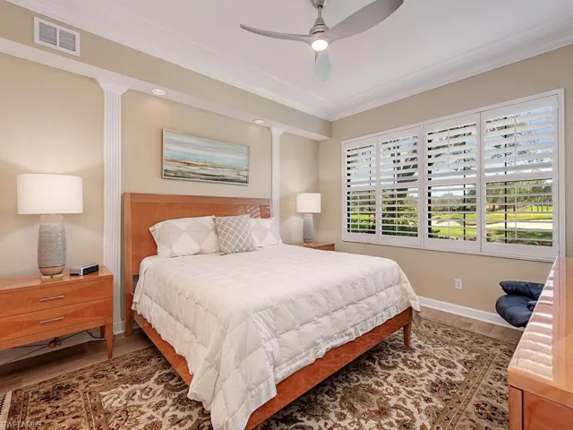 Bedroom featuring visible vents, crown molding, baseboards, and wood finished floors