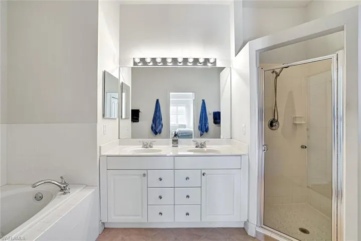 Ensuite bathroom with double sinks and a stall  shower