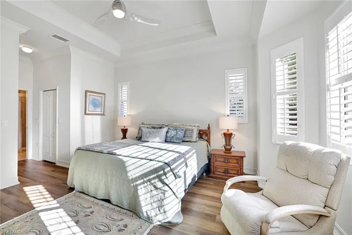Spacious Primary bedroom featuring 2 walk in closets,plantation Shutters,  Crown molding & a tray ceiling,