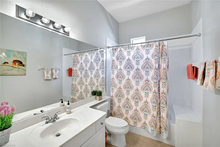 Full bathroom with toilet, vanity, tile and shower / tub combo