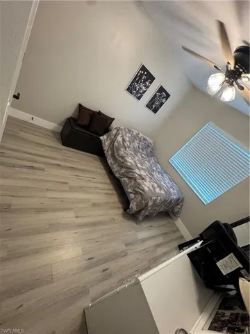 Wood-finish flooring throughout, featuring a vaulted ceiling and a ceiling fan with integrated lighting