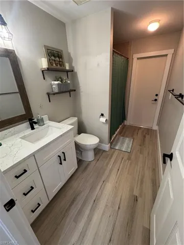 Modern bathroom featuring a white vanity with a rectangular sink, a white countertop with grey veining, and matte black hardware