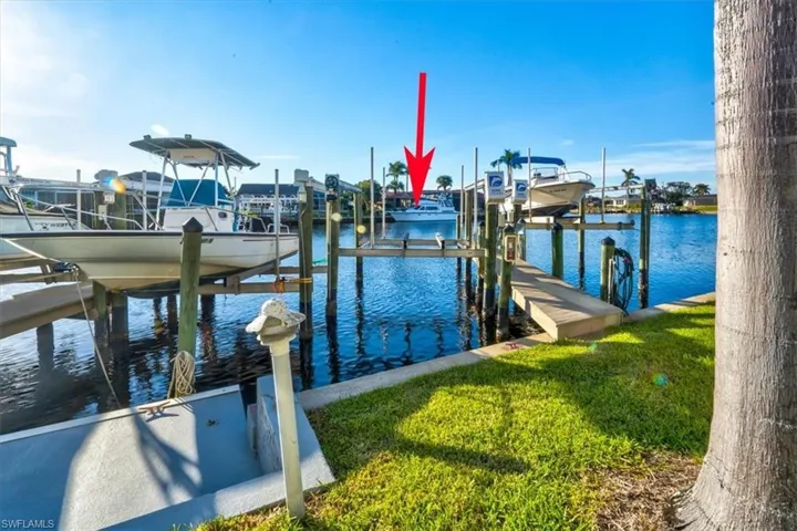 Dock area with a water view and a lawn