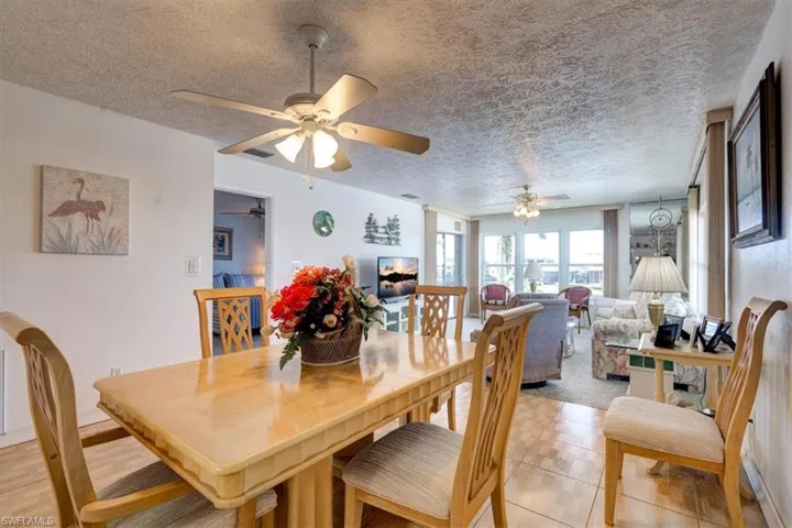 Tiled dining room with ceiling fan and a textured ceiling