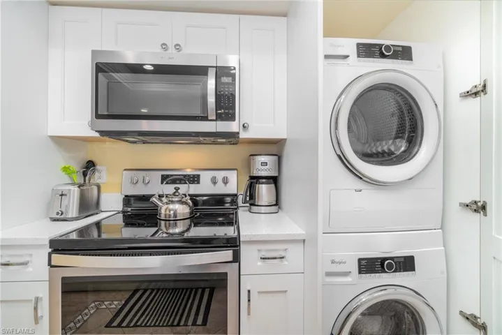 Laundry room with stacked washer and clothes dryer