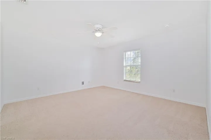 Carpeted guest bedroom room with ceiling fan