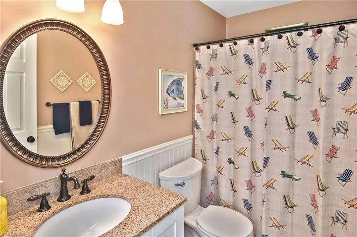 Full bathroom featuring a wainscoted wall, vanity, and curtained shower