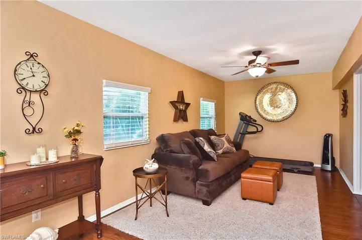 Living room with dark wood-type flooring and ceiling fan