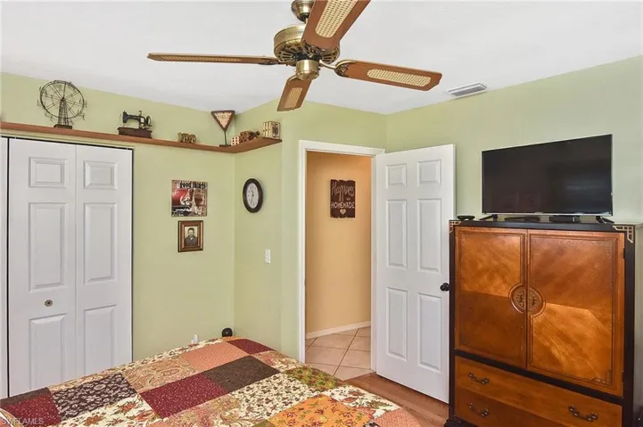 Bedroom with a closet, a ceiling fan, and light tile patterned flooring