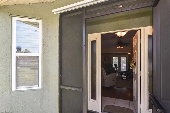 View of exterior entry with stucco siding and french doors