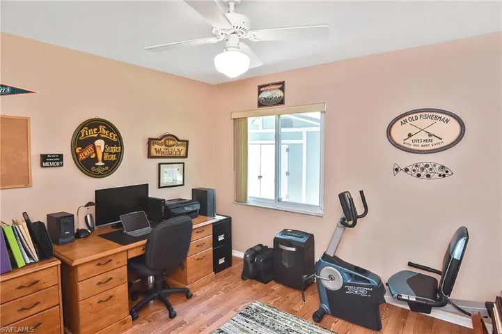 Home office with light wood-style flooring and a ceiling fan