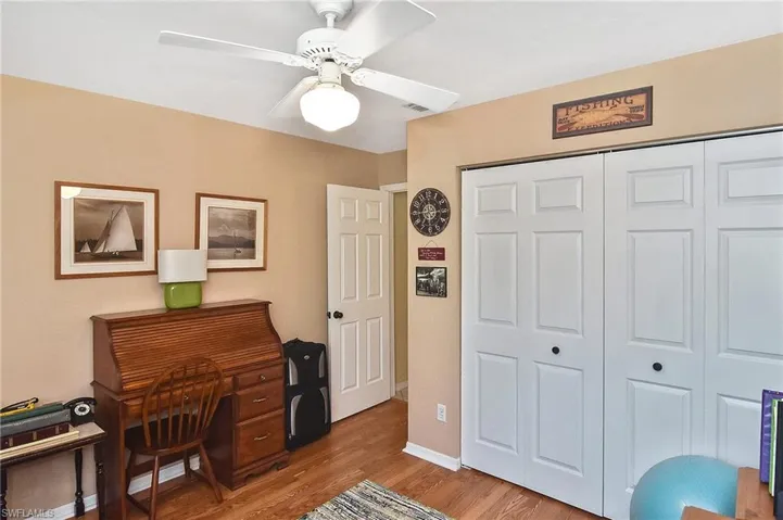 Home office with wood finished floors and a ceiling fan