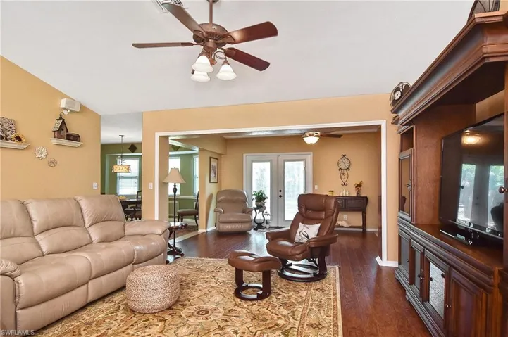 Living area featuring ceiling fan, dark wood-type flooring, and french doors