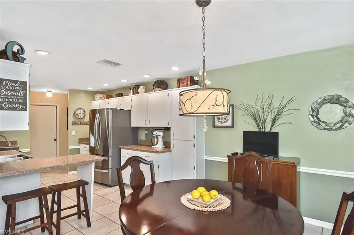 Dining space with light tile patterned floors and recessed lighting