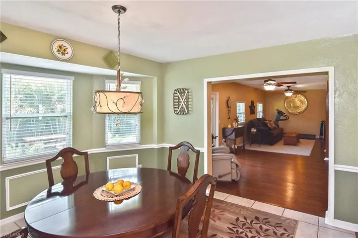 Dining area with light tile patterned floors, plenty of natural light, and a ceiling fan
