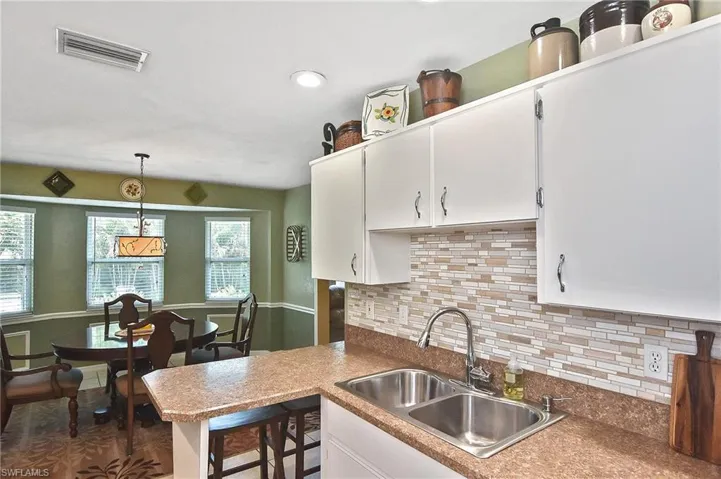 Kitchen featuring plenty of natural light, white cabinets, backsplash, and recessed lighting