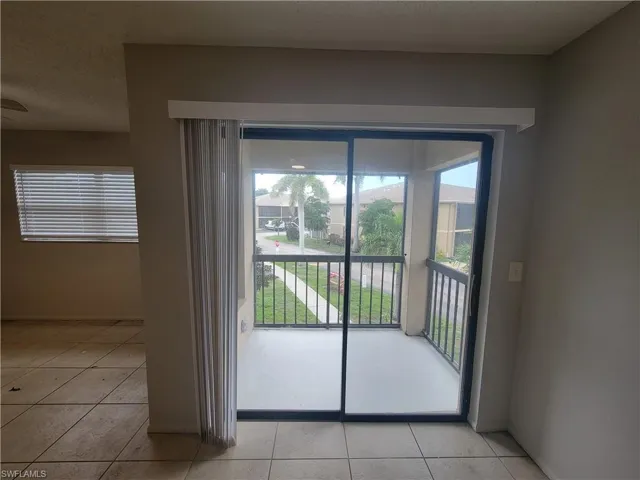 Doorway to outside featuring a textured ceiling and tile patterned flooring