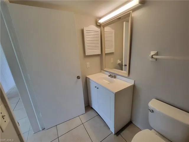Half bathroom featuring vanity and light tile patterned floors
