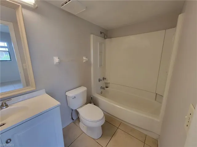 Full bath featuring light tile patterned flooring, shower / washtub combination, and vanity