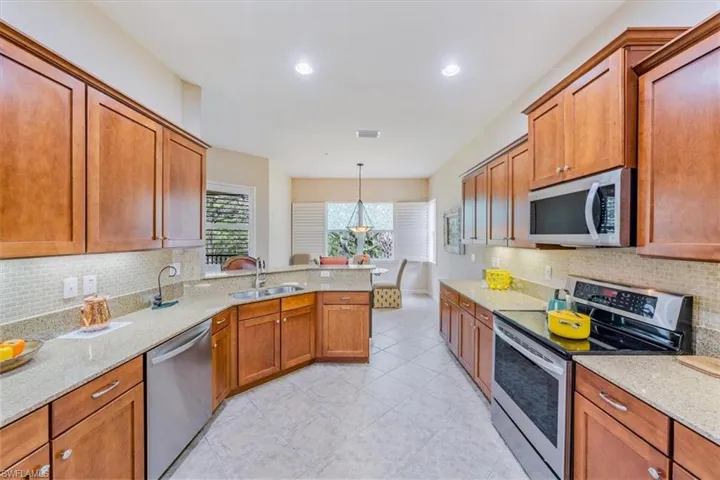 Expansive granite countertops and tiled backsplash in this cook's kitchen.