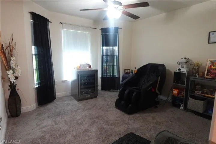Sitting room featuring carpet flooring and ceiling fan