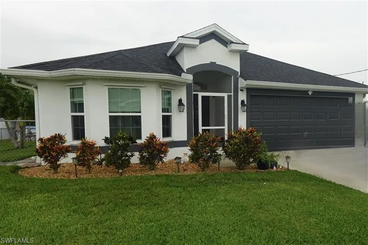 View of front of property with a garage and a front yard