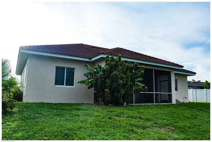 Rear view of house featuring a lawn and a sunroom