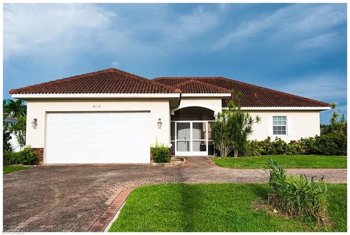 Mediterranean / spanish-style house with a front lawn and a garage