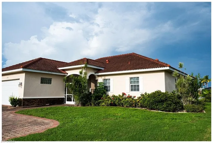 View of front of house featuring a garage and a front lawn