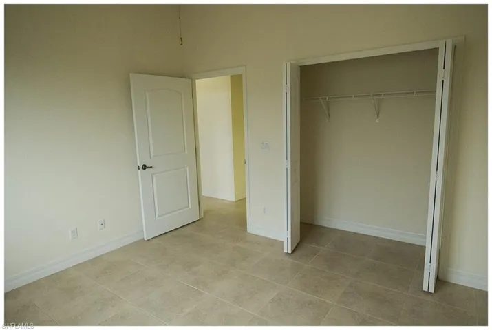 Unfurnished bedroom with light tile patterned floors and a closet