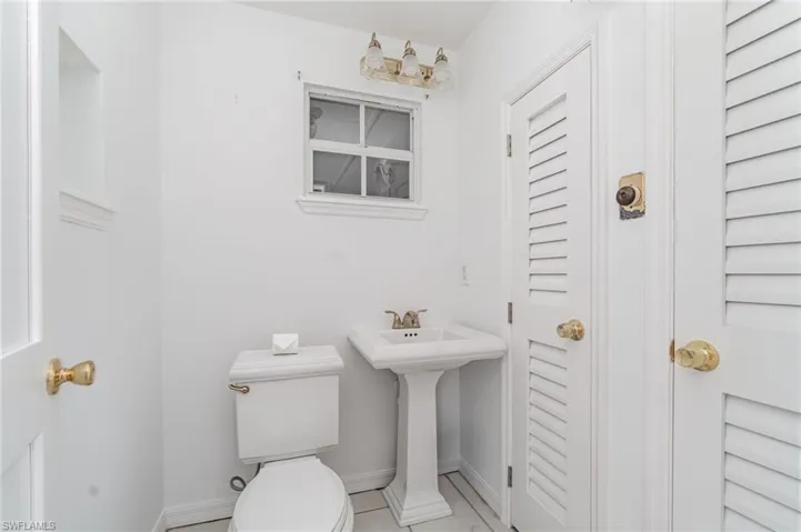 Bathroom with toilet, baseboards, and a sink