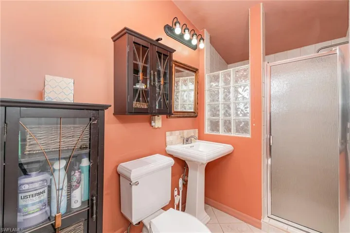 Full bathroom with a stall shower, toilet, and tile patterned floors