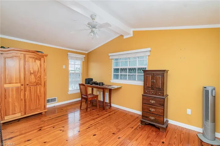 Office area with a ceiling fan, light wood finished floors, baseboards, and crown molding