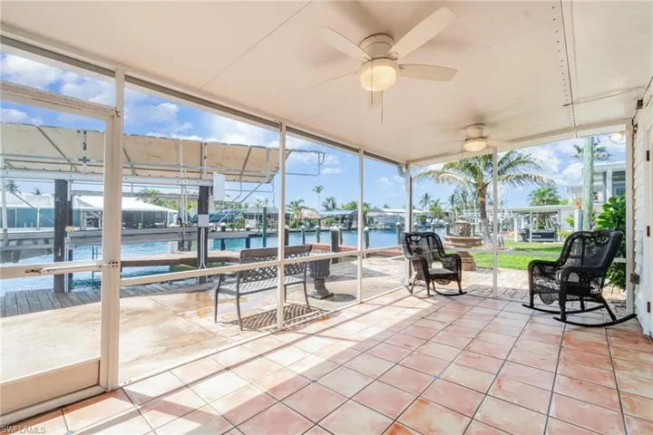 Sunroom with a water view, a ceiling fan, and healthy amount of natural light