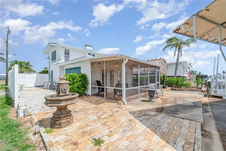 Rear view of house with a patio, french doors, a chimney, a sunroom, and a ceiling fan