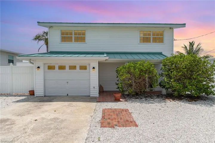 Traditional-style home with a garage, metal roof, and a standing seam roof